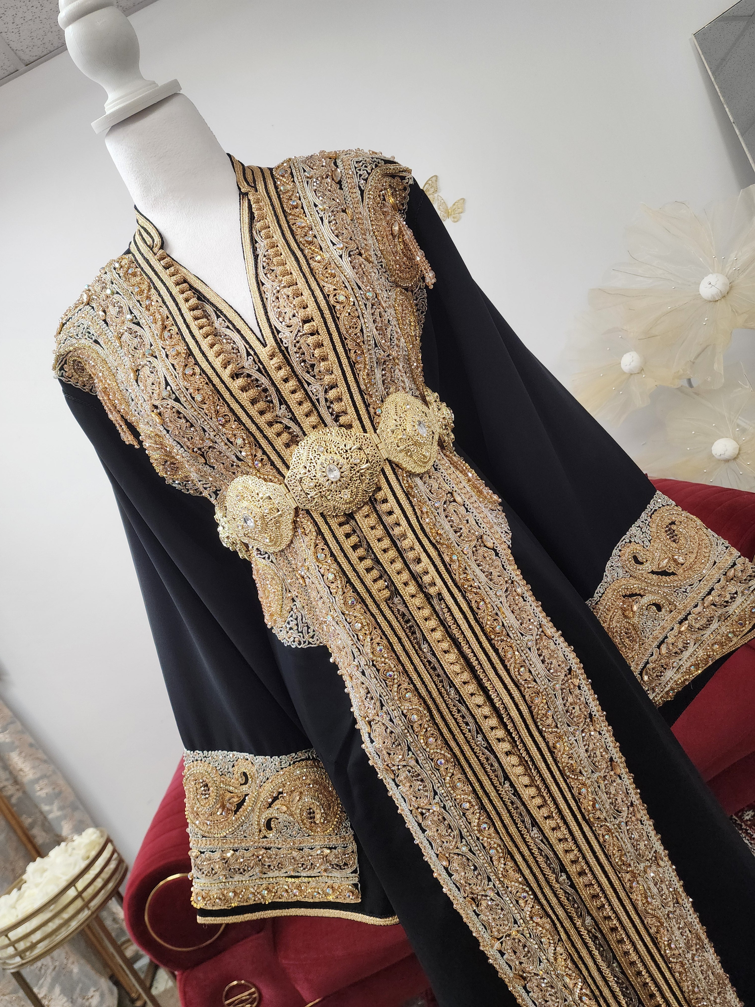 Luxury black Moroccan caftan handcrafted in Morocco with hand-beaded gold and silver embroidery, silk crepe fabric, matching belt, available in Canada and USA by Maison Farhat
Caftan marocain noir de luxe en crêpe de soie avec broderie artisanale dorée et argentée, perlage à la main, fabriqué au Maroc, disponible au Canada et aux États-Unis par Maison Farhat.
